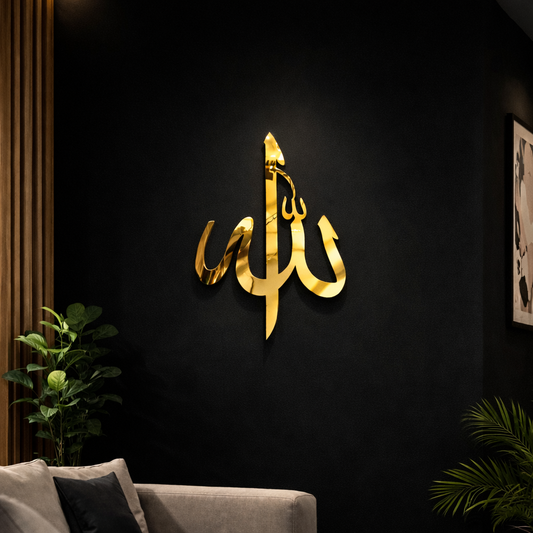 Gold Arabic calligraphy wall art on a black wall with a gray sofa and plants.