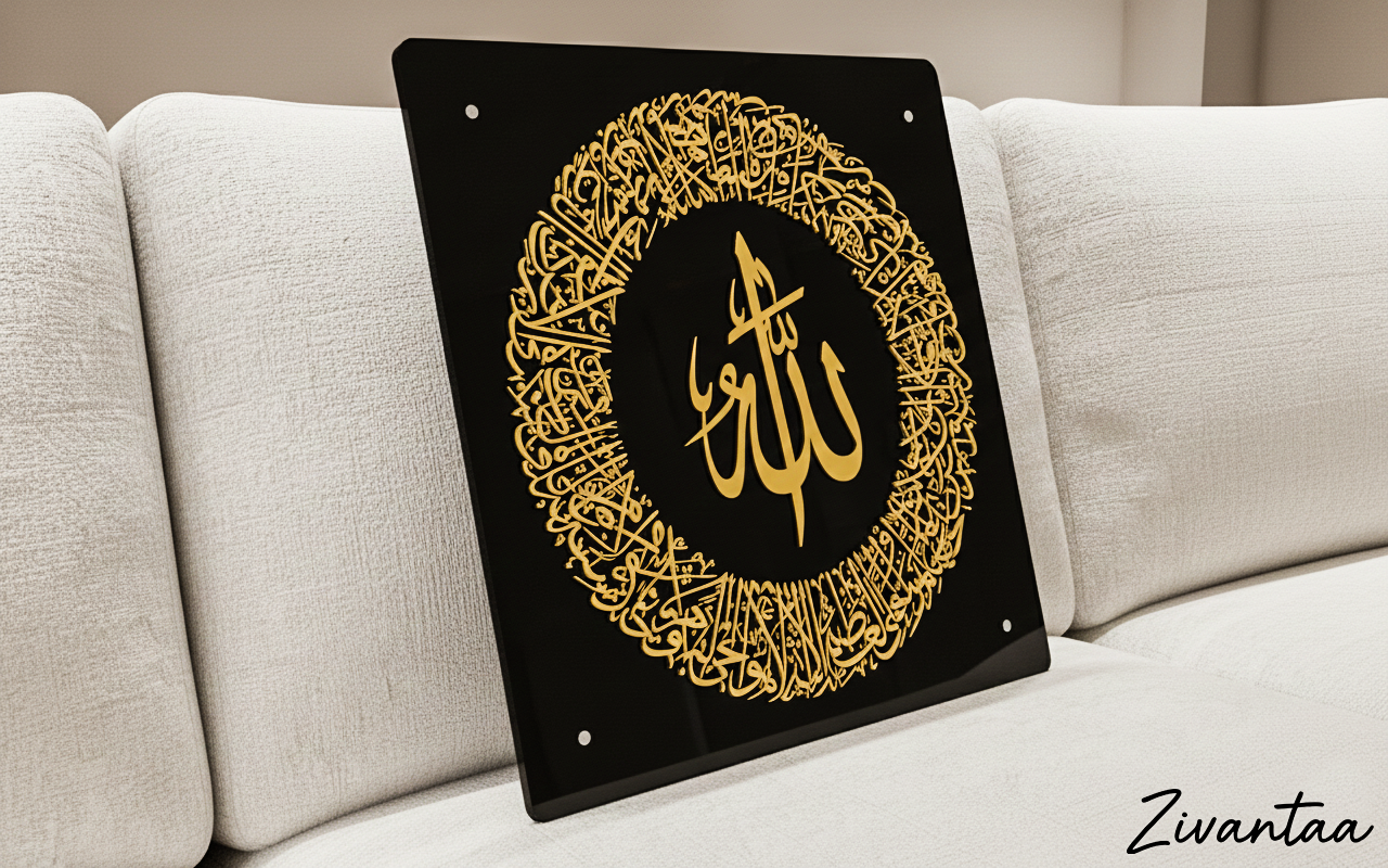 Decorative sign with gold Arabic calligraphy on a black background, placed on a light-colored sofa.