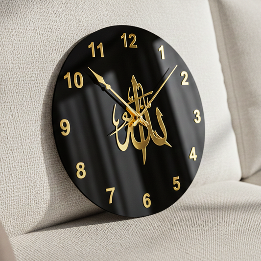 Black wall clock with gold Arabic calligraphy and numbers on a beige background