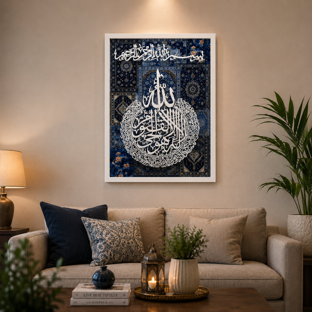 A framed Islamic wall art print featuring white Arabic calligraphy on a dark blue patterned background, displayed above a beige sofa in a styled living room setting.