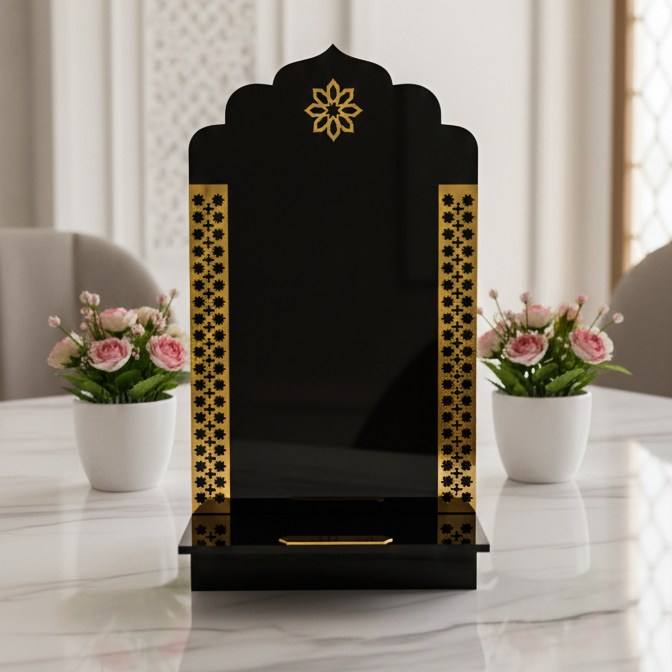 Black and gold decorative item with floral arrangements on a marble surface