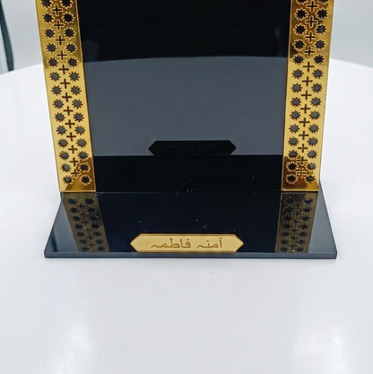 Decorative black and gold frame with intricate patterns on a white surface