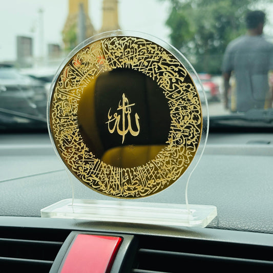 Decorative plate with gold calligraphy on a car dashboard