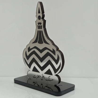 Decorative bottle-shaped object with black and white pattern on a gray background