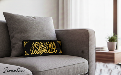 Decorative pillow with Arabic calligraphy on a gray sofa in a living room setting.