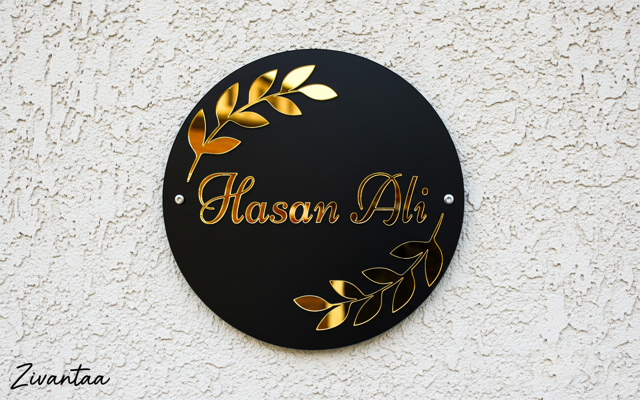 Round black sign with gold text and leaf designs on a white textured wall, featuring the brand 'Zwantaa'.