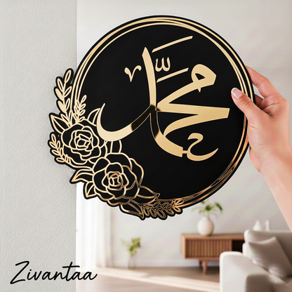 Decorative wall art with Arabic calligraphy and floral design held by a hand in a room.