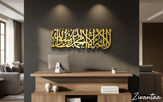 Modern living room with a wooden desk, computer monitor, and decorative items. Gold Arabic calligraphy on the wall.