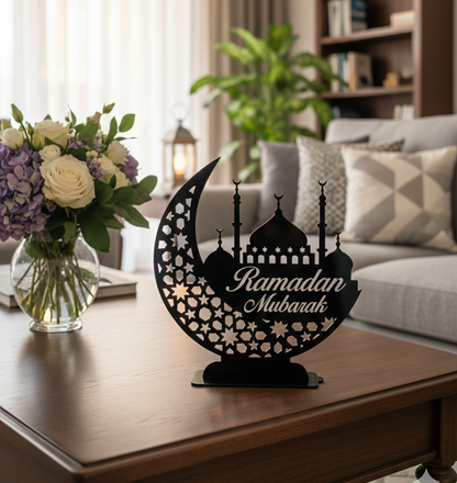Decorative moon-shaped sign with 'Ramadan Mubarak' on a table in a living room.