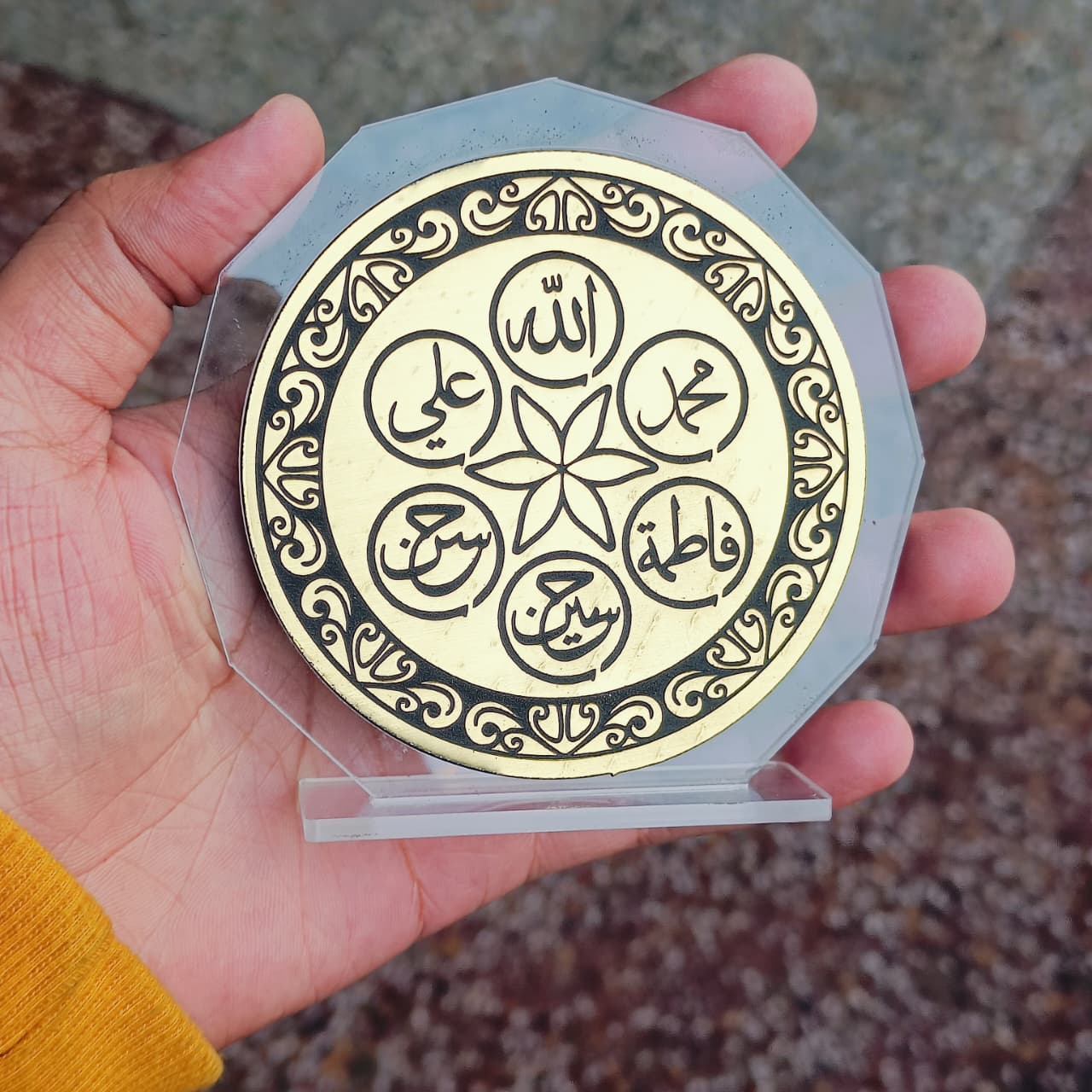 Decorative plate with Arabic calligraphy held by a hand